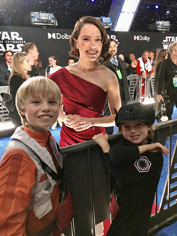 Daisy Ridley poses with two young fans.