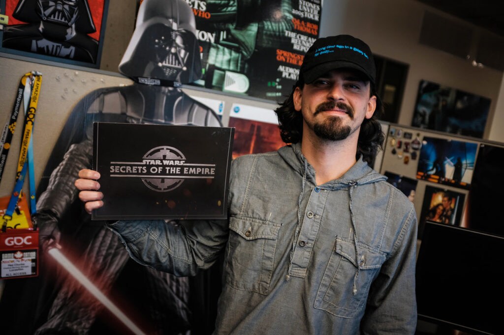 A member of the Lucasfilm Games Team holds up artwork for Star Wars: Secrets of the Empire.