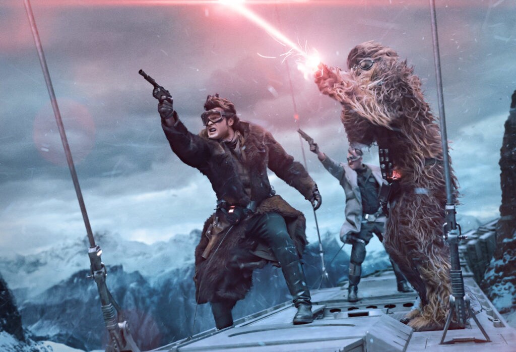 Han Solo, Chewbacca, and Tobias Beckett shoot blasters while riding on top of a train.