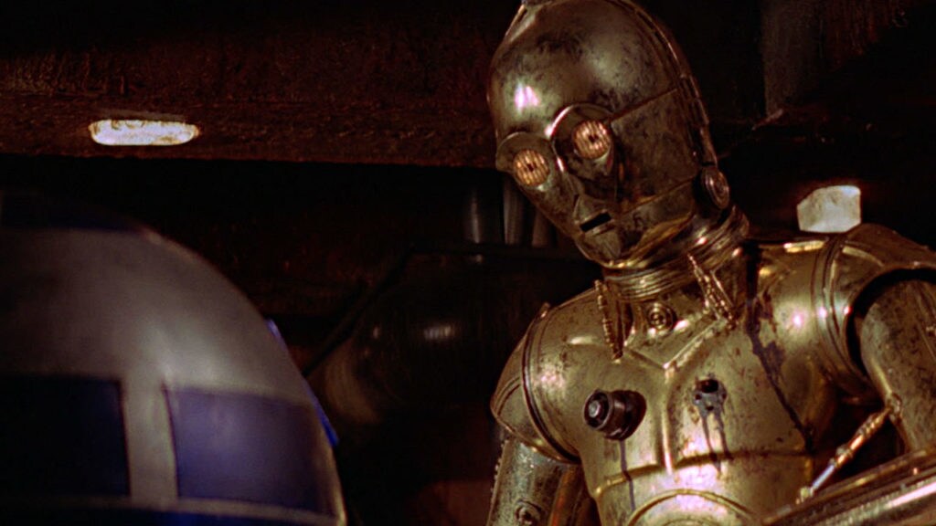 C-3PO looks at R2-D2.