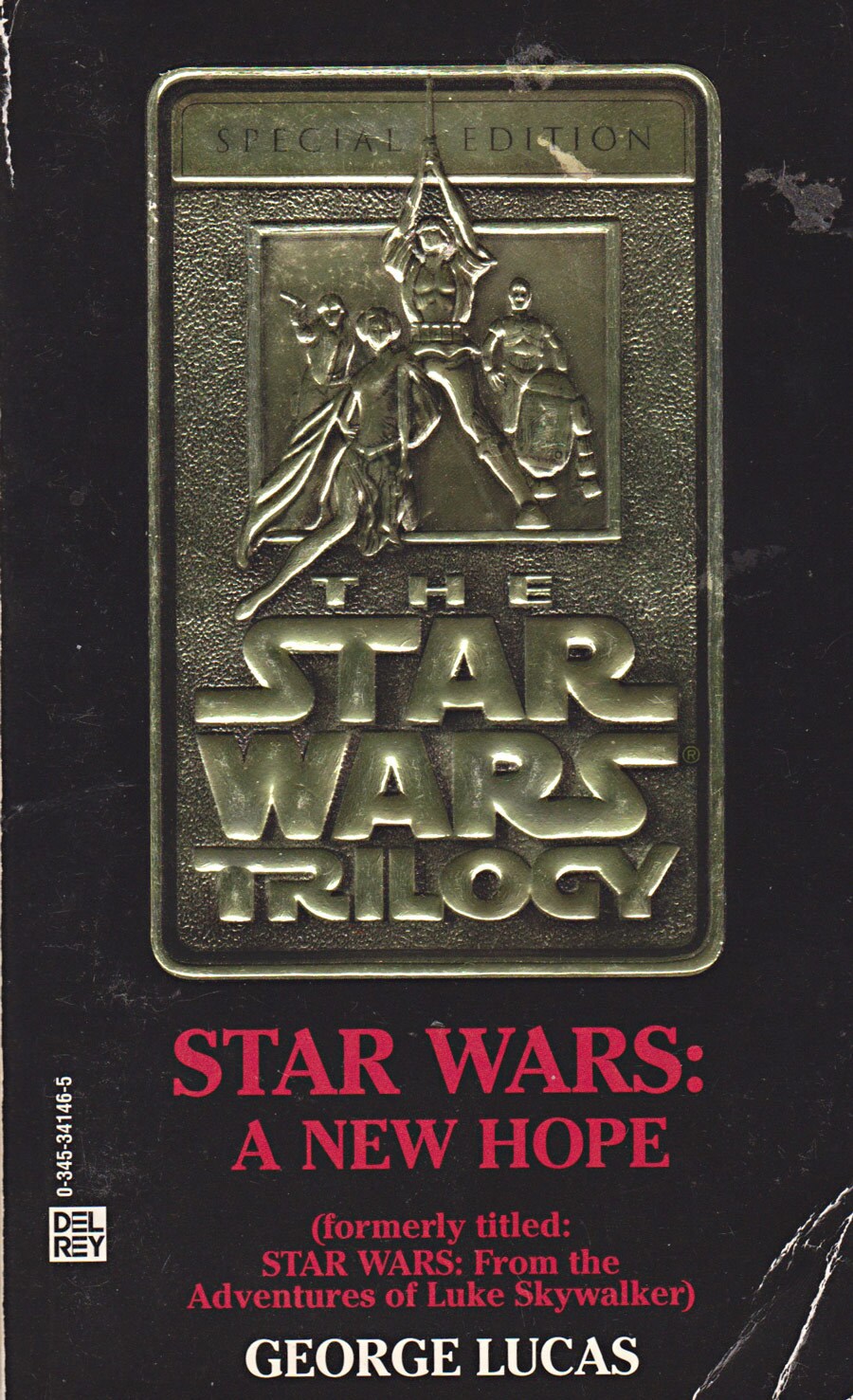 The gold-embossed special edition cover of the book Star Wars: A New Hope, by George Lucas. The cover features Han, Leia, Luke, R2, and C-3PO.