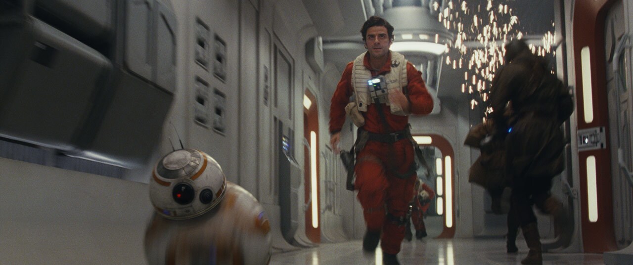 Poe and BB-8 hurry down a hallway in The Last Jedi.