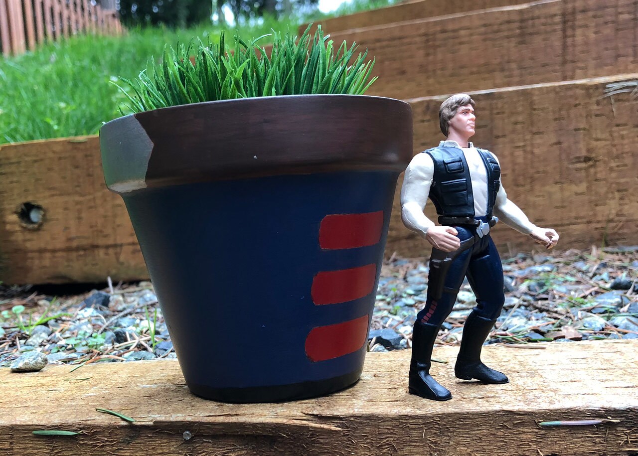 A DIY painted Star Wars themed pot with a Han Solo action figure.