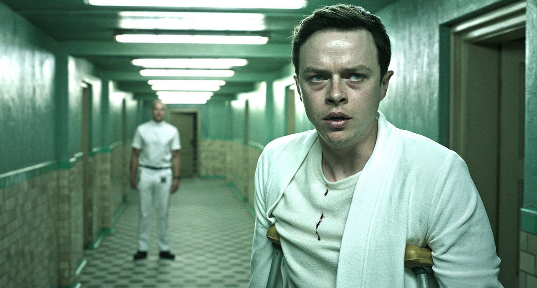 Actor Dane DeHaan (Lockhart) with a character watching him in the film "A Cure for Wellness"