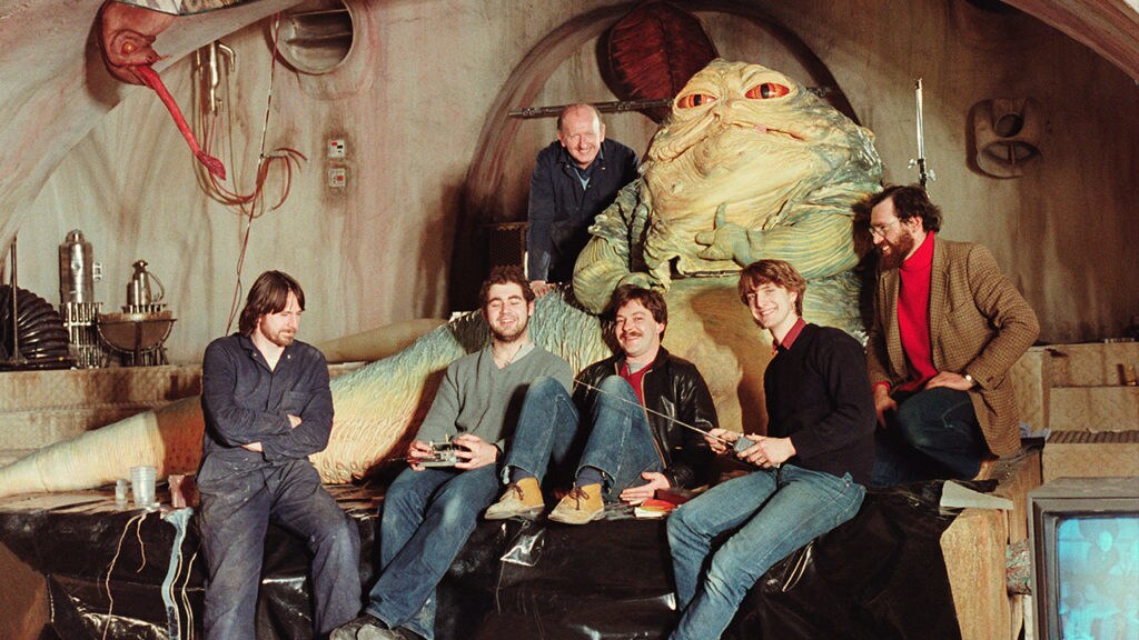 The six-person team who controlled Jabba the Hutt in Return of the Jedi pose for a photo with the Jabba puppet seen in the movie.