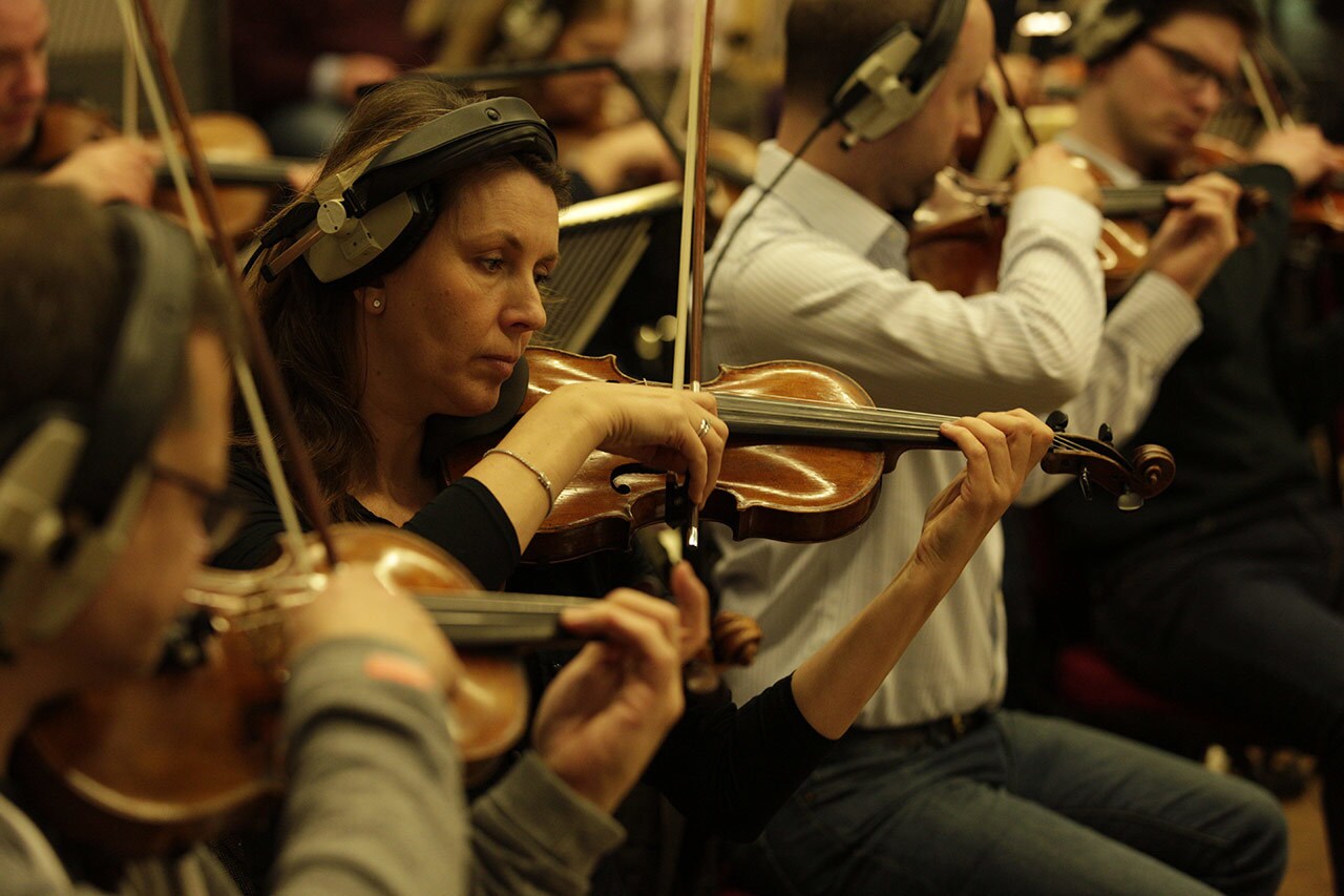 Violinists wear headphones while playing during a recording session for the score of Solo: A Star Wars Story.