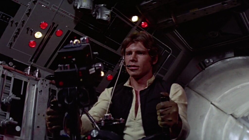 Han Solo sits at the controls inside a gunner turret of the Millennium Falcon in A New Hope.