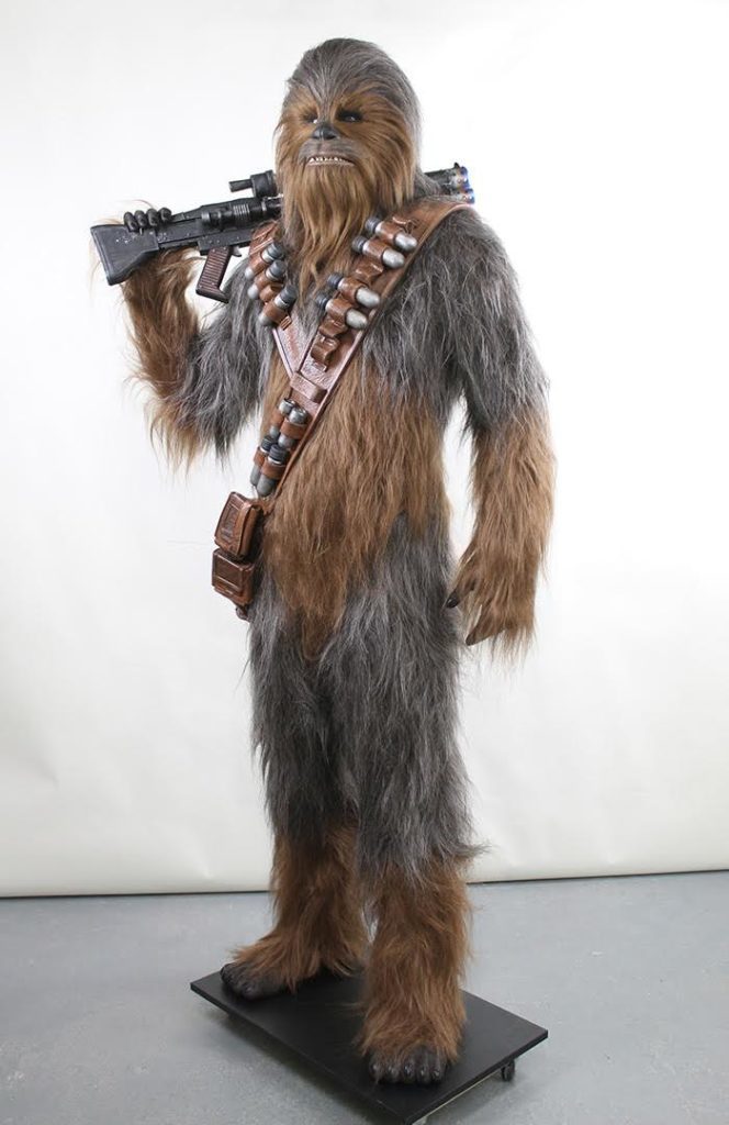 A life-sized replica of Chewbacca, holding a bowcaster over his shoulder.