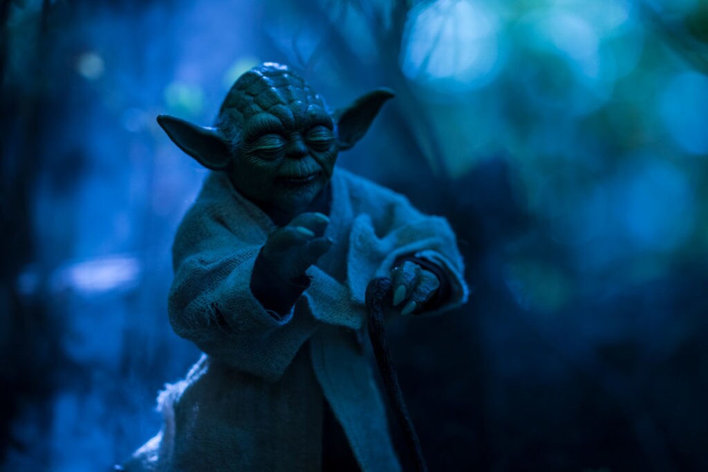 Yoda, in toy form, shot realistically against a blue backdrop.