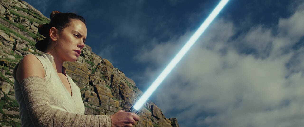 Rey ignites her lightsaber.