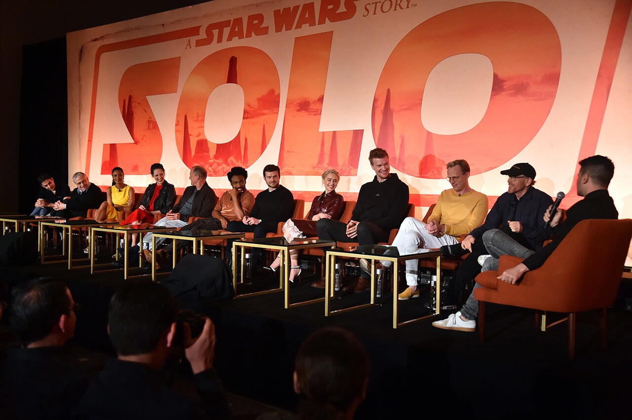 The cast and crew of Solo: A Star Wars Story in front of a Solo poster answer questions about the movie.