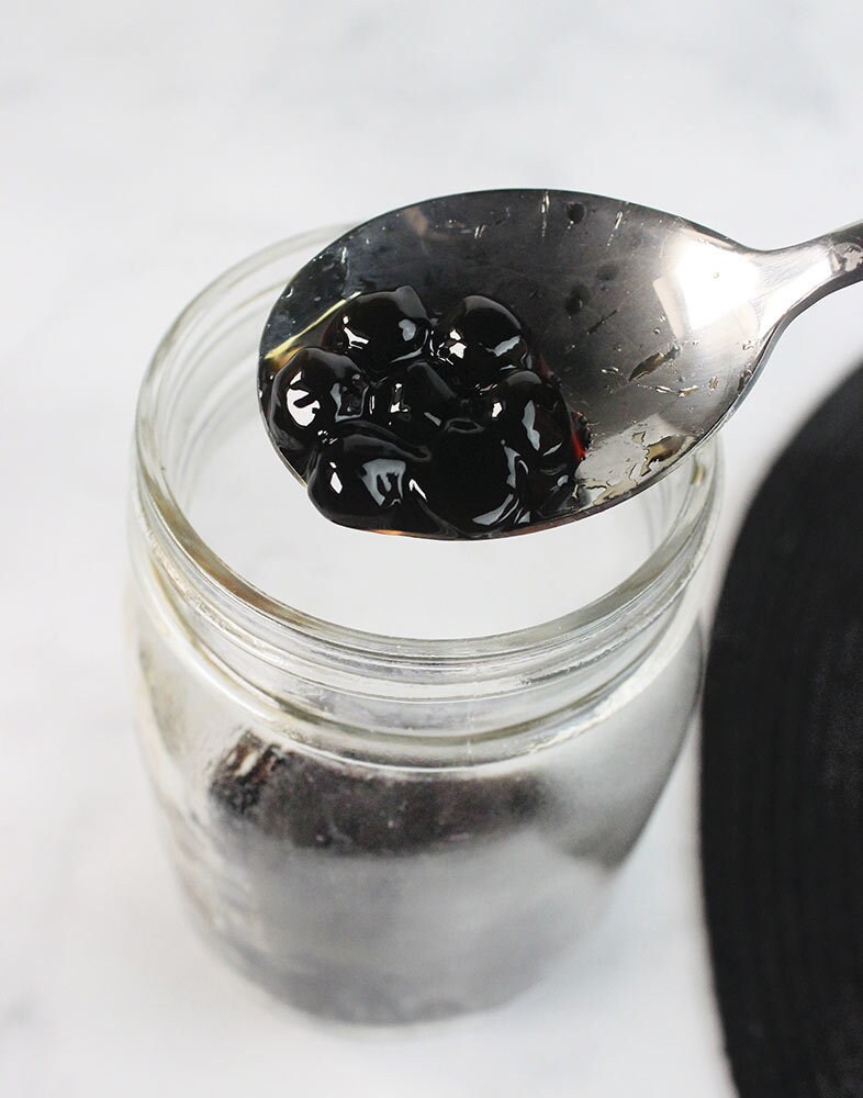 Drain and spoon the boba into a tall serving glass