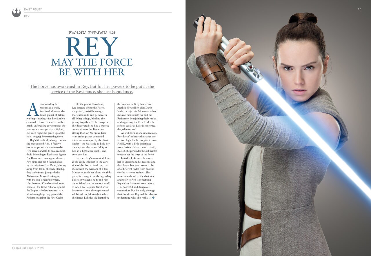 Two pages from the collector's edition souvenir guide to The Last Jedi show an article about the character Rey, on the left, and a photo of Rey holding a lightsaber, on the right.