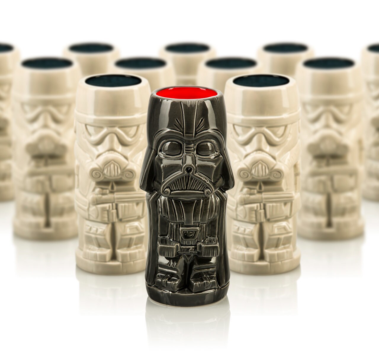 A Darth Vader themed tiki mug in front of a group of Stormtrooper themed tiki mugs.
