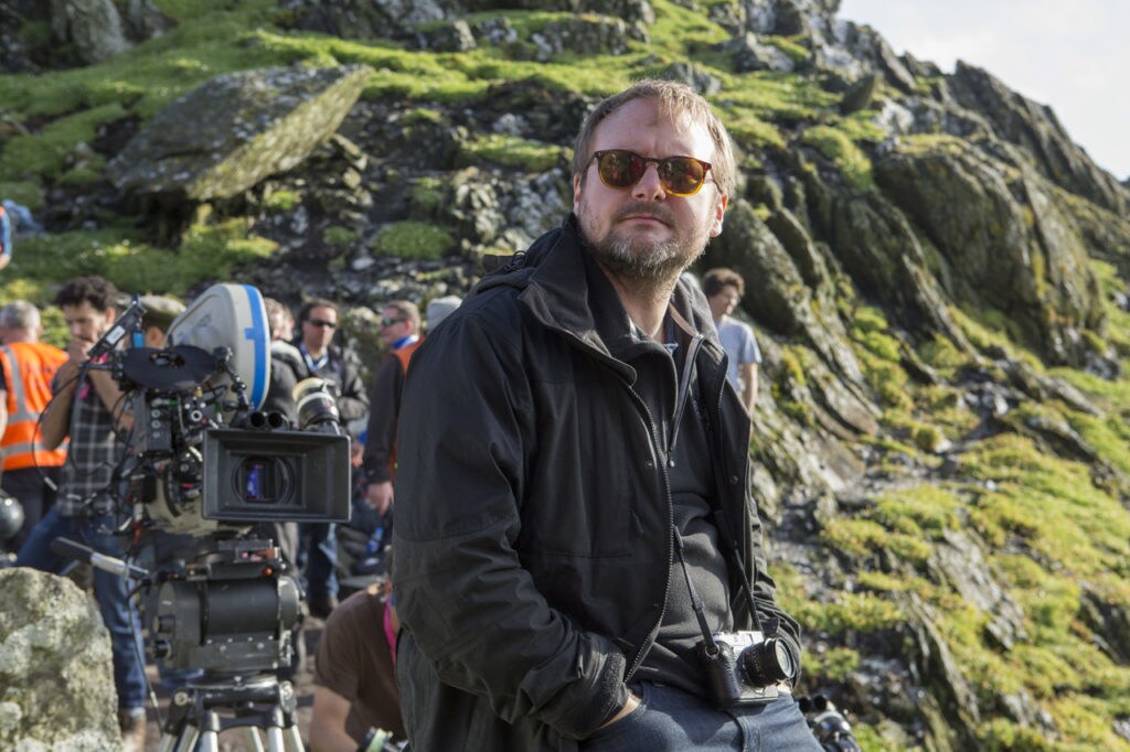 Director Rian Johnson looks off in the distance with his camera and crew behind him while on a location shoot for The Last Jedi.