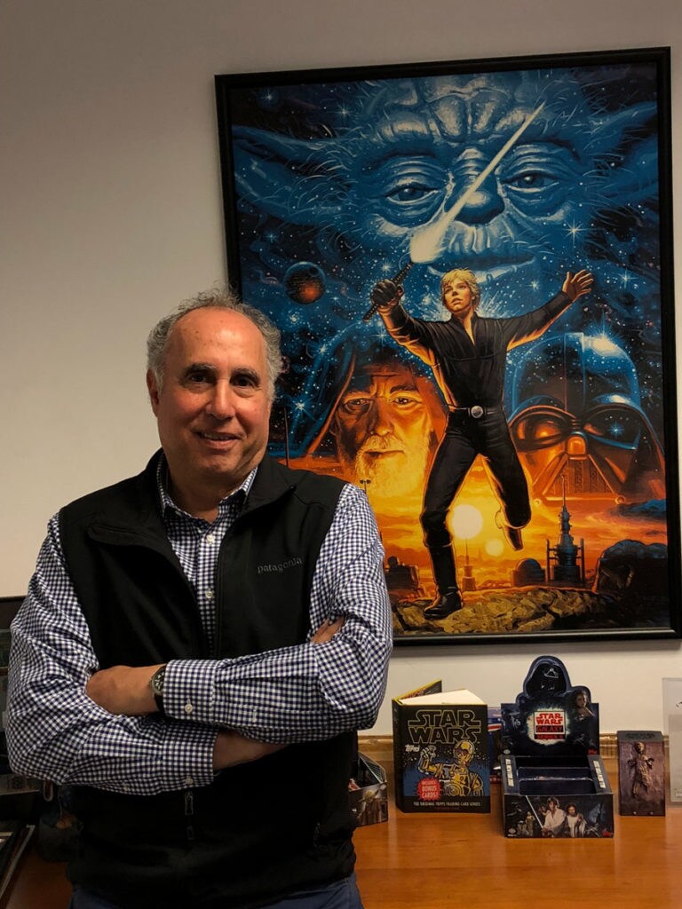 Ida Friedman stands in front of a Star Wars poster and merchandise.