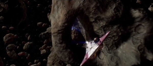 A Jedi starfighter flies through an asteroid field.