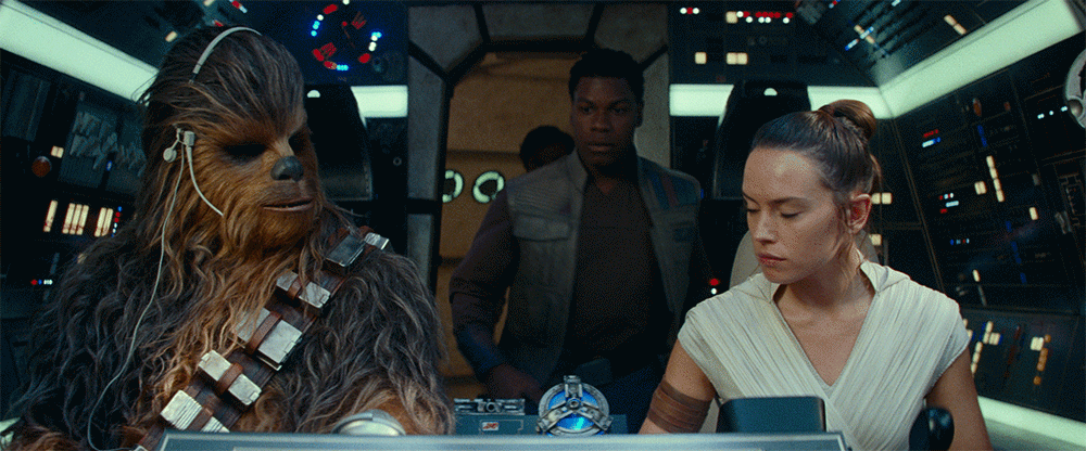 Rey and Chewbacca pilot the Millennium Falcon as Finn and Poe enter the cockpit, in a GIF.