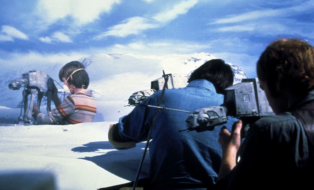 A stop motion team positions AT-AT models on a soundstage, behind the scenes of The Empire Strikes Back.