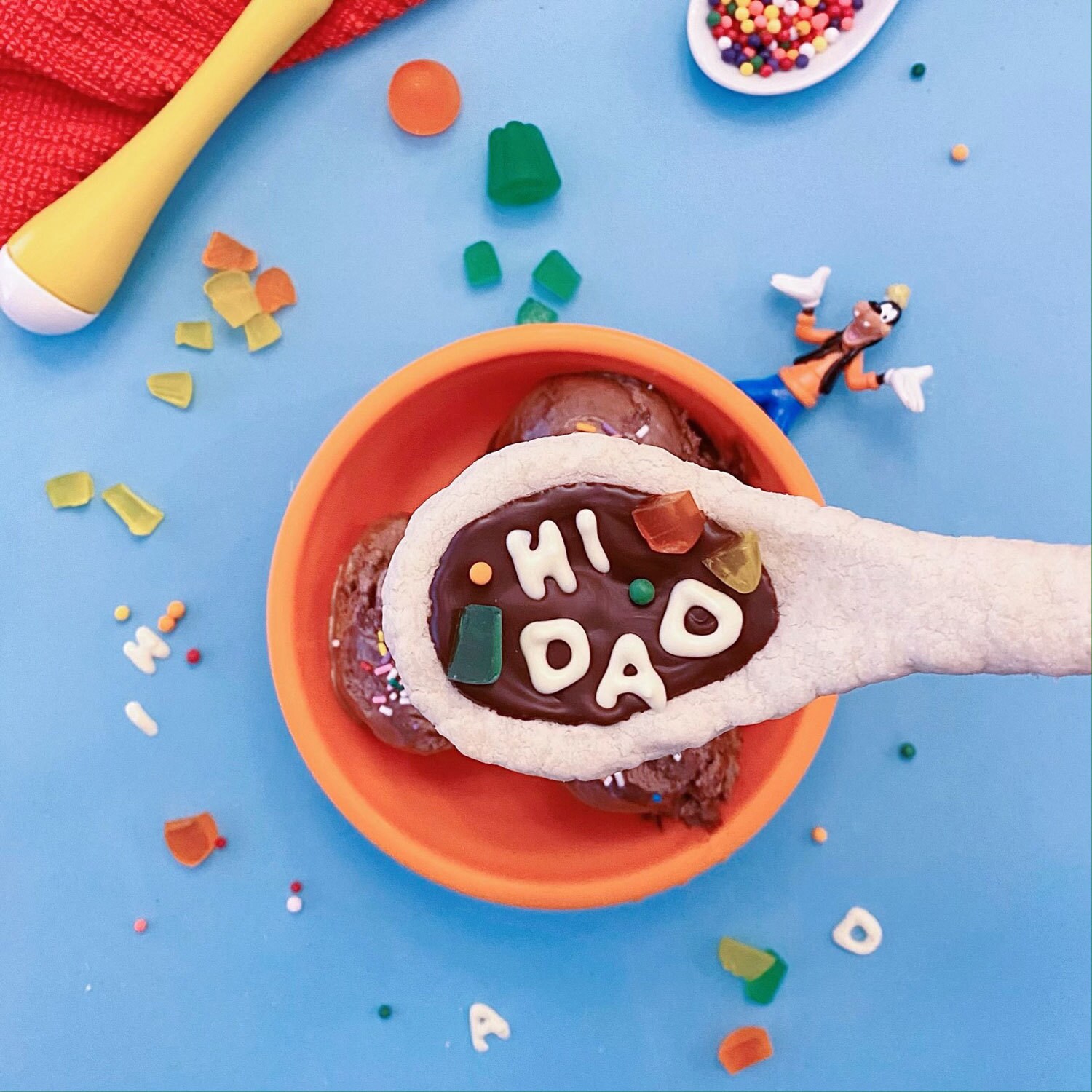 A cookie shaped like a soup spoon, decorated with the phrase "Hi Dad," and inspired by A Goofy Movie.
