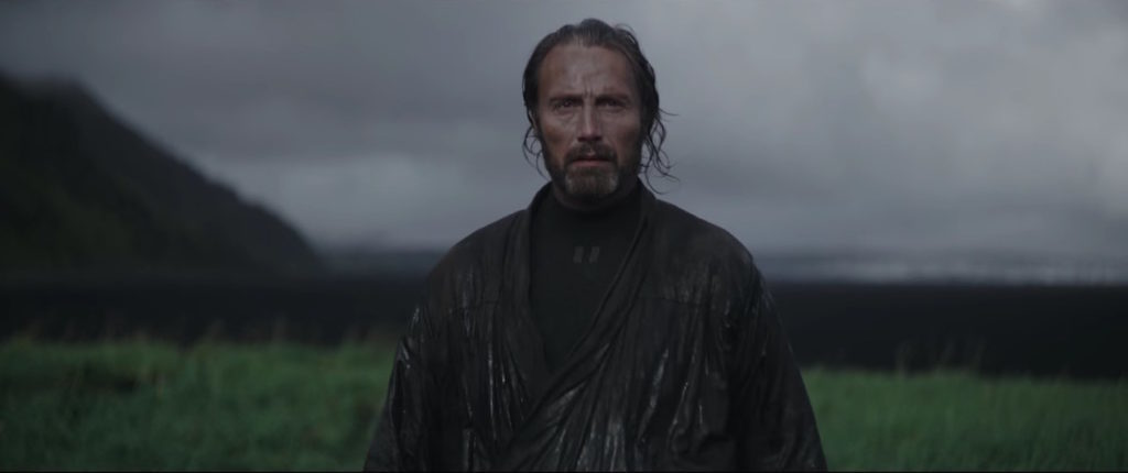 Galen Erso stands in a grassy field in Rogue One.
