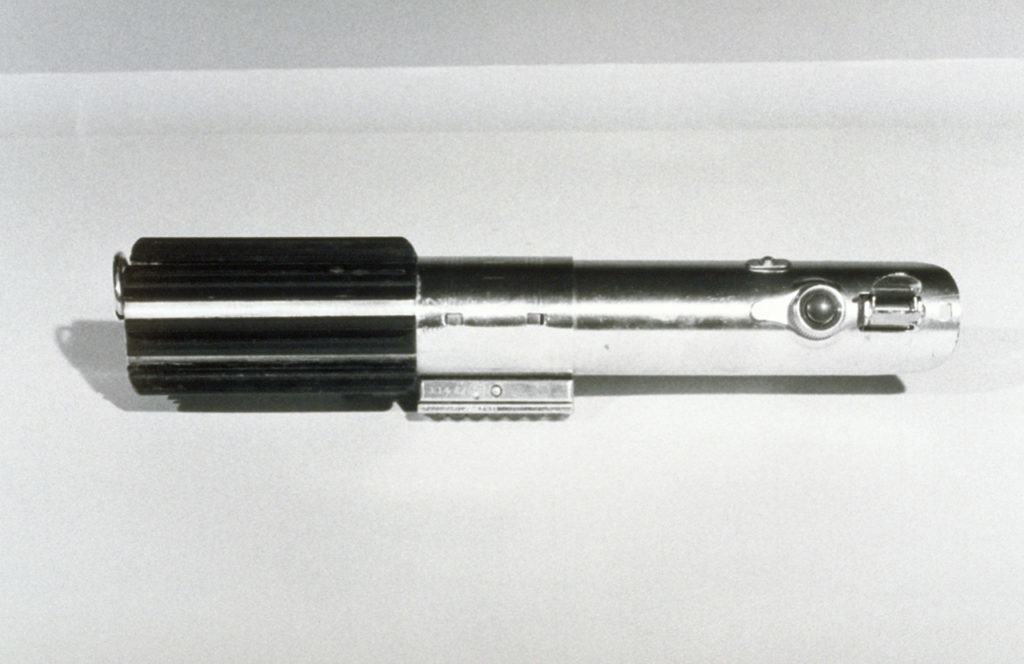 A lightsaber handle, photographed in black and white.