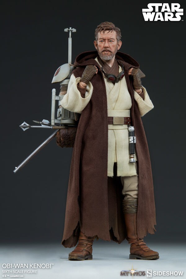 The Star Wars Mythos Obi-Wan Kenobi action figure grips his backpack in his Jedi uniform.