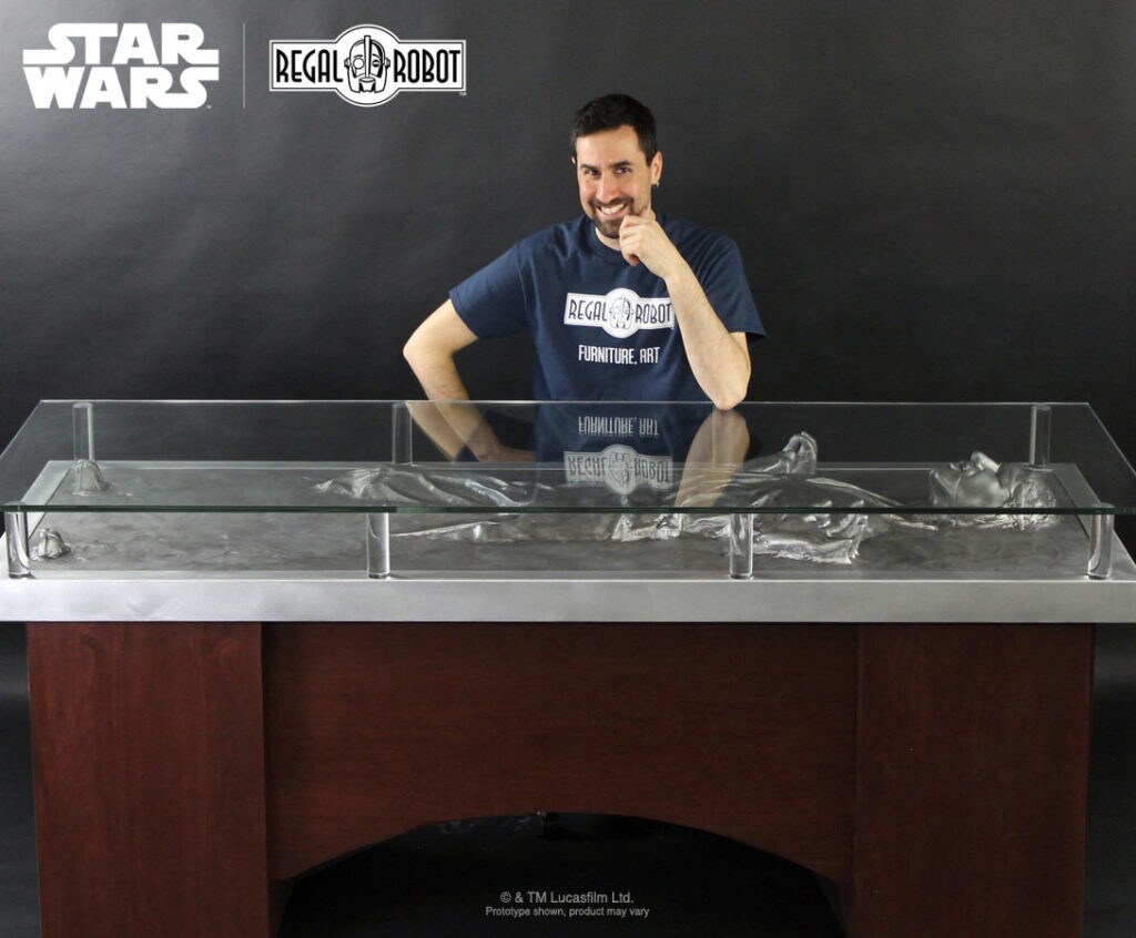 Visual artist Tom Spina poses with a desk modeled after Han Solo in carbonite.