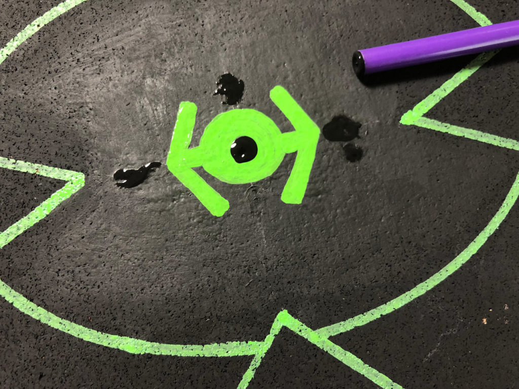 A black cork board targeting computer with a green TIE FIGHTER and black paint.