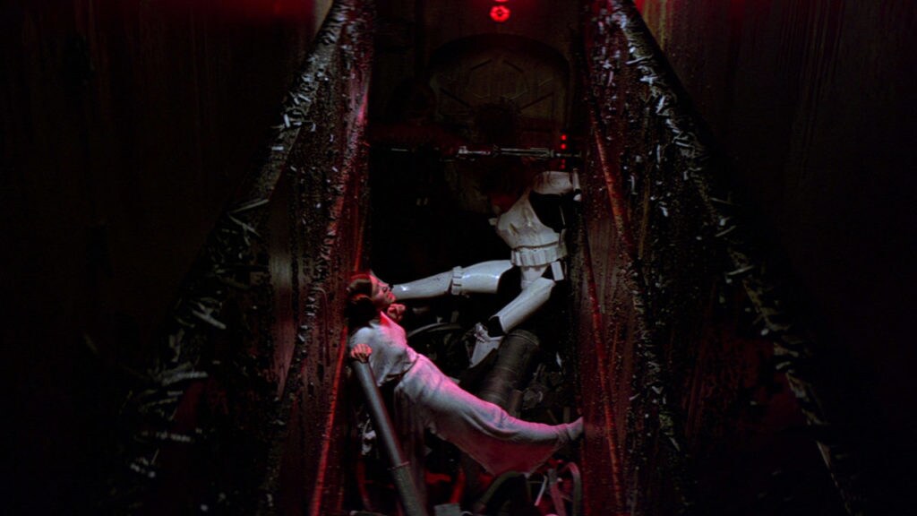 Princess Leia and Han Solo push against the walls of the Death Star's trash compactor as it crushes them.