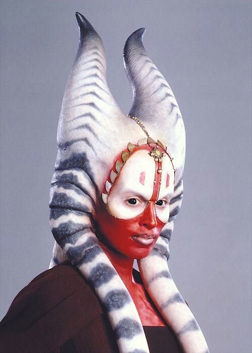 A person cosplaying as Shaak Ti, a Togruta with a red face and grey and white montrals.