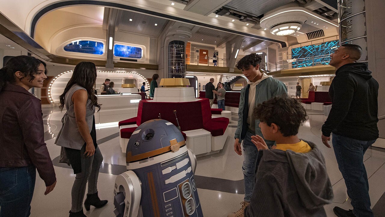 Astromech droid SK-62O greets guests in the Atrium of the Halcyon starcruiser in Star Wars: Galactic Starcruiser at Walt Disney World Resort in Lake Buena Vista, Fla. (Matt Stroshane, photographer)