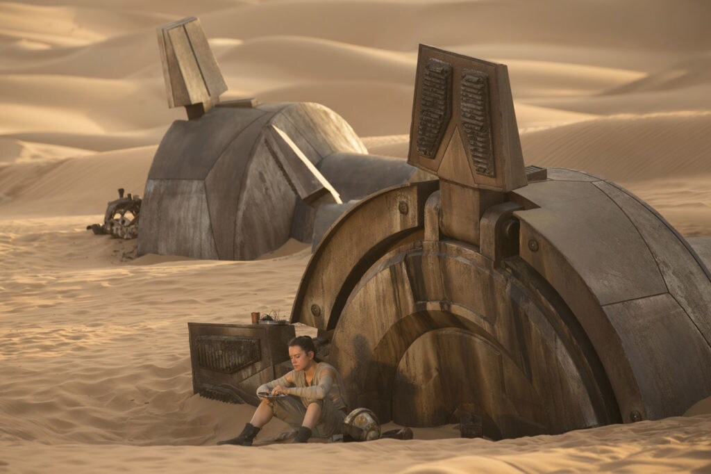 Rey sits outside a downed AT-AT.