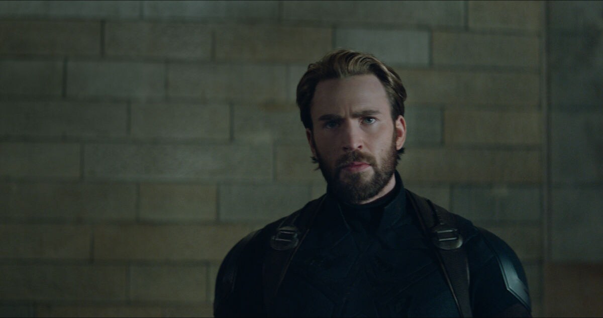 Captain America stands against a brick wall in this scene from Avengers: Infinity War.