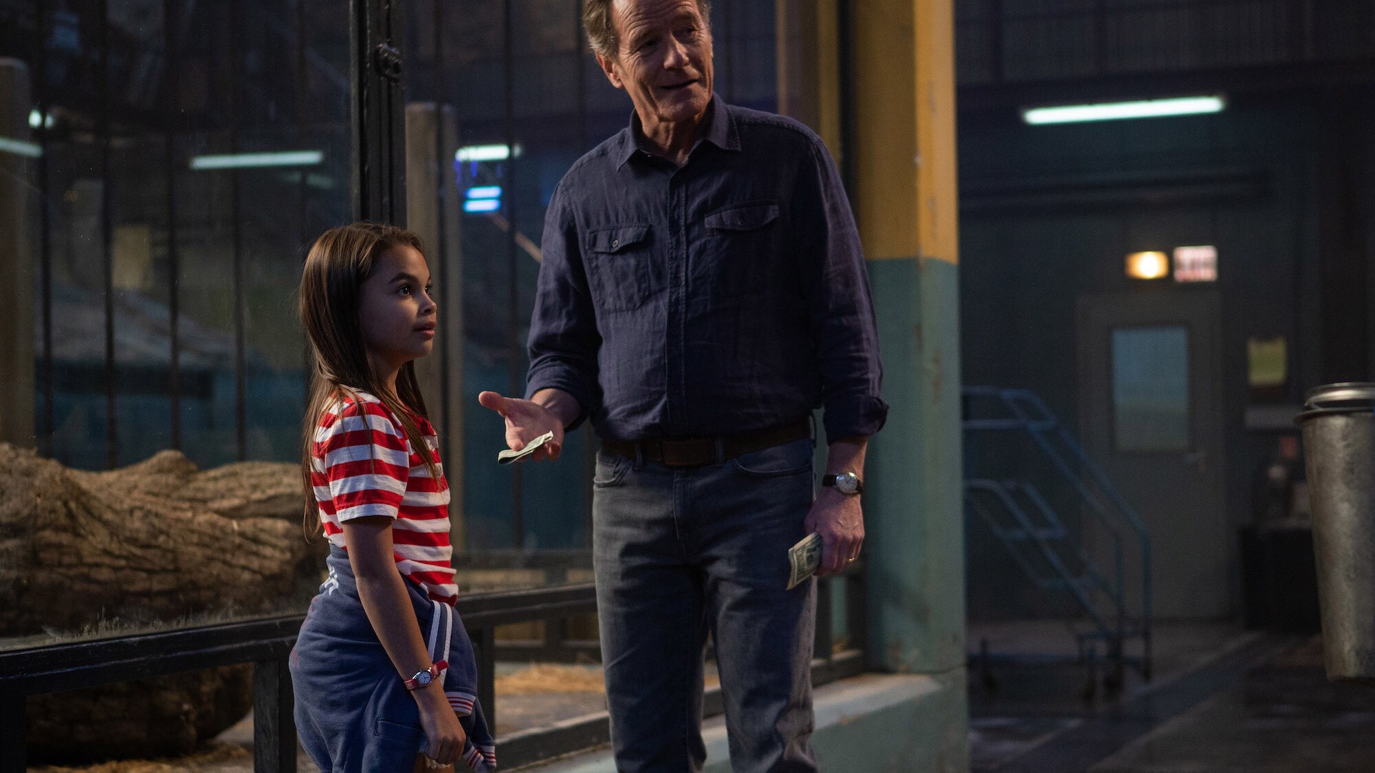 Ariana Greenblatt as Julia and Bryan Cranston as Mack in Disney’s THE ONE AND ONLY IVAN, based on the award-winning book by Katherine Applegate and directed by Thea Sharrock. Photo courtesy of Disney. © 2020 Disney Enterprises, Inc. All Rights Reserved. 