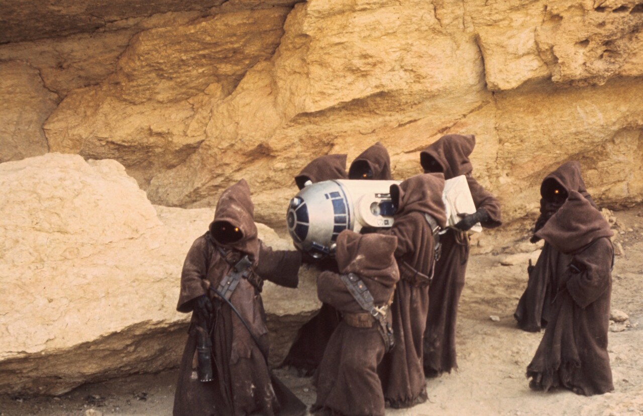 The Jawas carried the inert droid to their sandcrawler, fitting him with a restraining bolt and a...