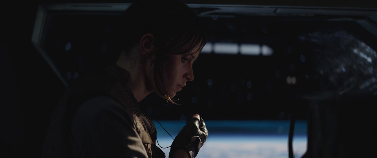 Jyn holds her necklace