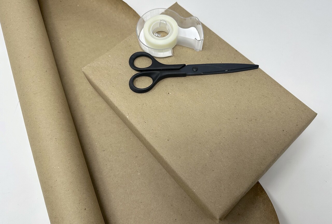 Cover the gift box in brown kraft paper as you would typically wrap a present.