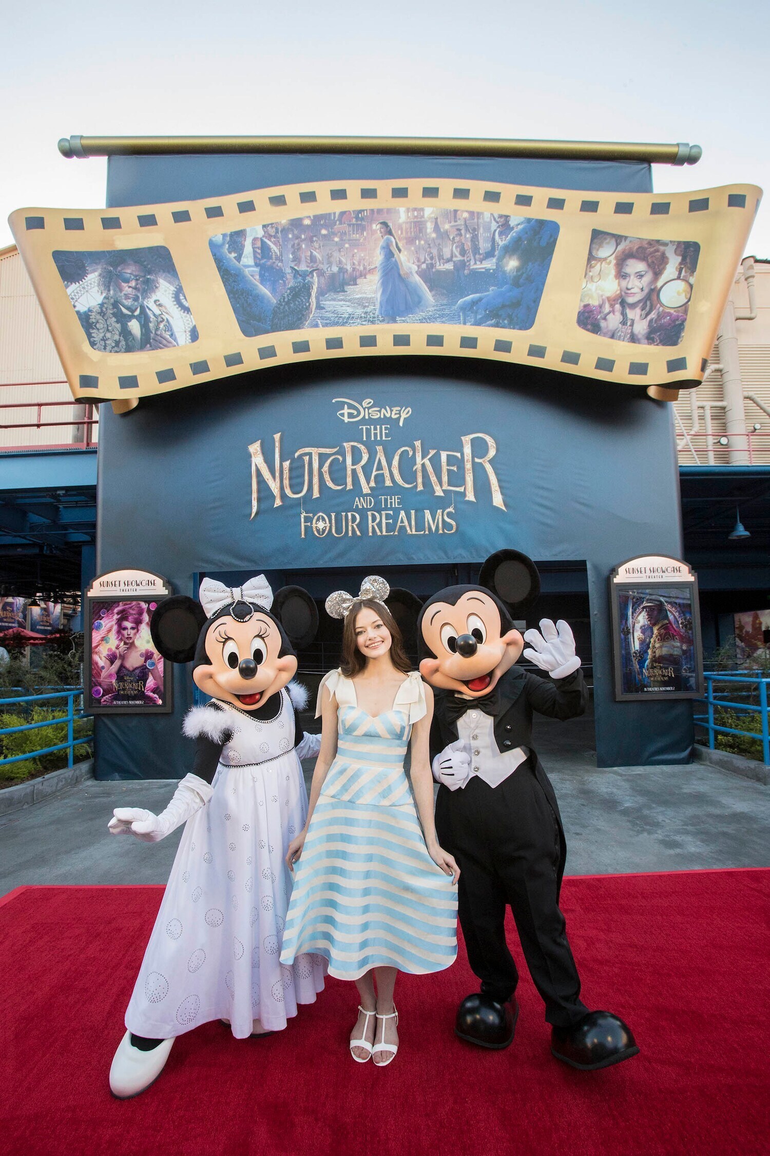 Mackenzie Foy posing with Minnie and Mickey at Disney The Nutcracker and the Four Realms