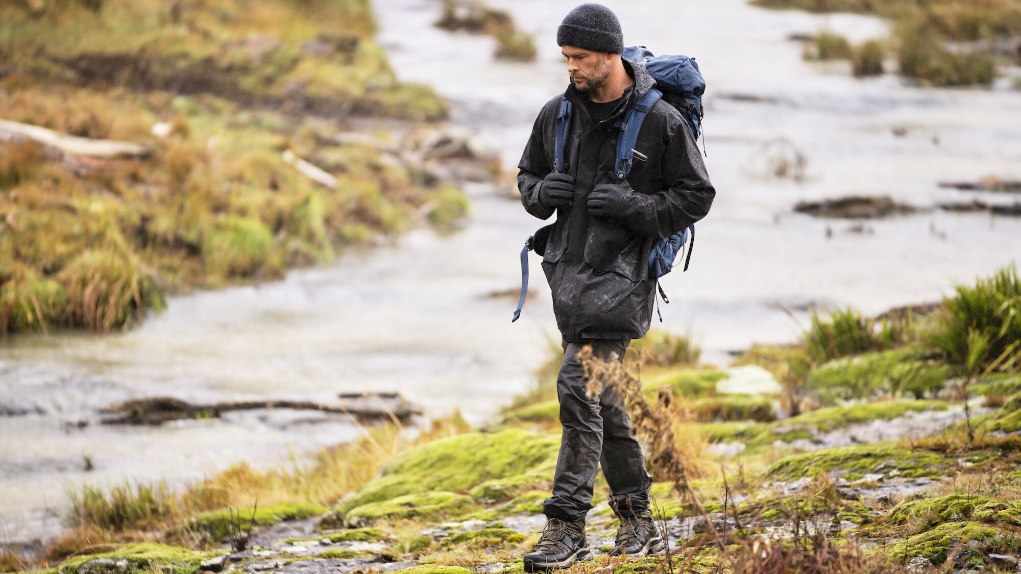 Chris Hemsworth walks along a stream. (National Geographic for Disney+/Craig Parry)