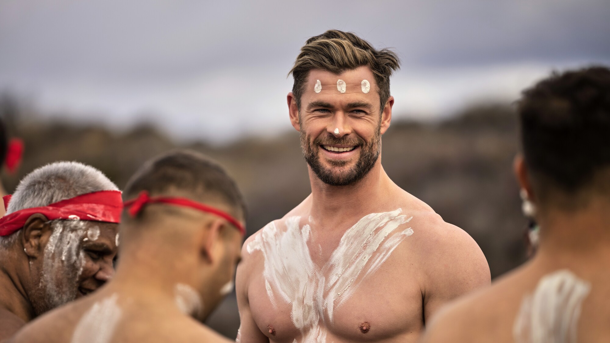 Chris Hemsworth dances with the first nation's tribe. (National Geographic for Disney+/Craig Parry)