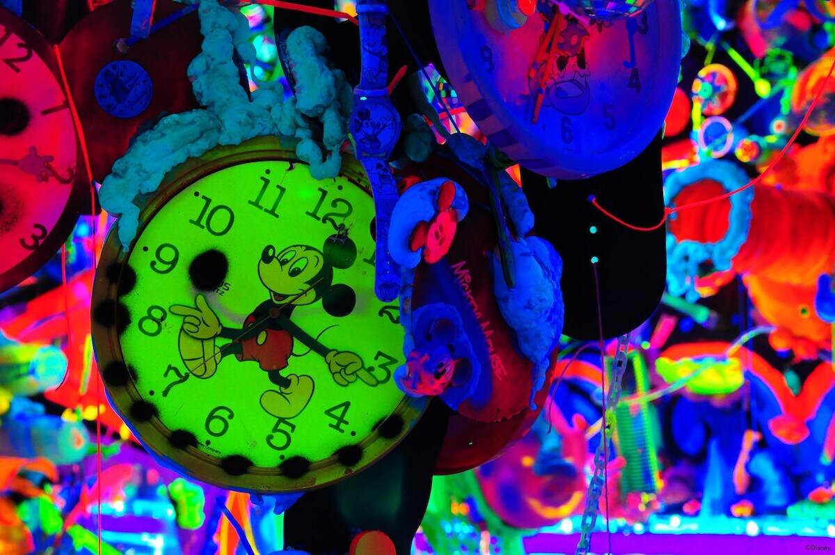 Multicolored neon Mickey Mouse art display with glowing green mickey watch