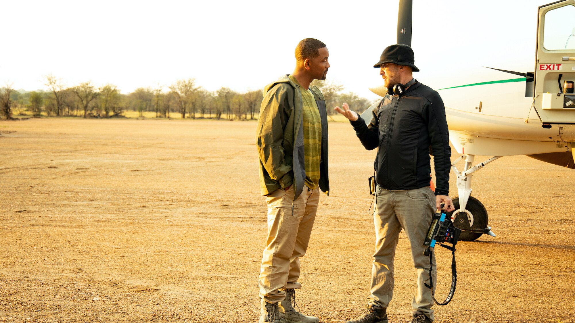 Will Smith, left, and Executive Producer Darren Aronofsky talk during their travels to the Serengeti to film the migrations.  (National Geographic for Disney+/Kyle Christy)