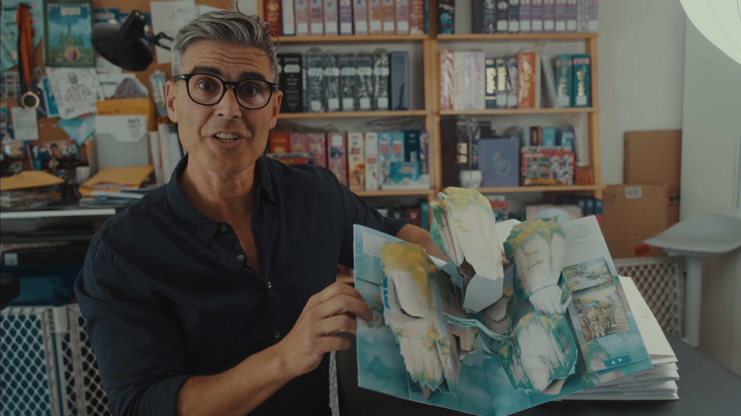 Image of author Matthew Reinhart holding an opened page of Avatar: The Ultimate Pop-Up Book.