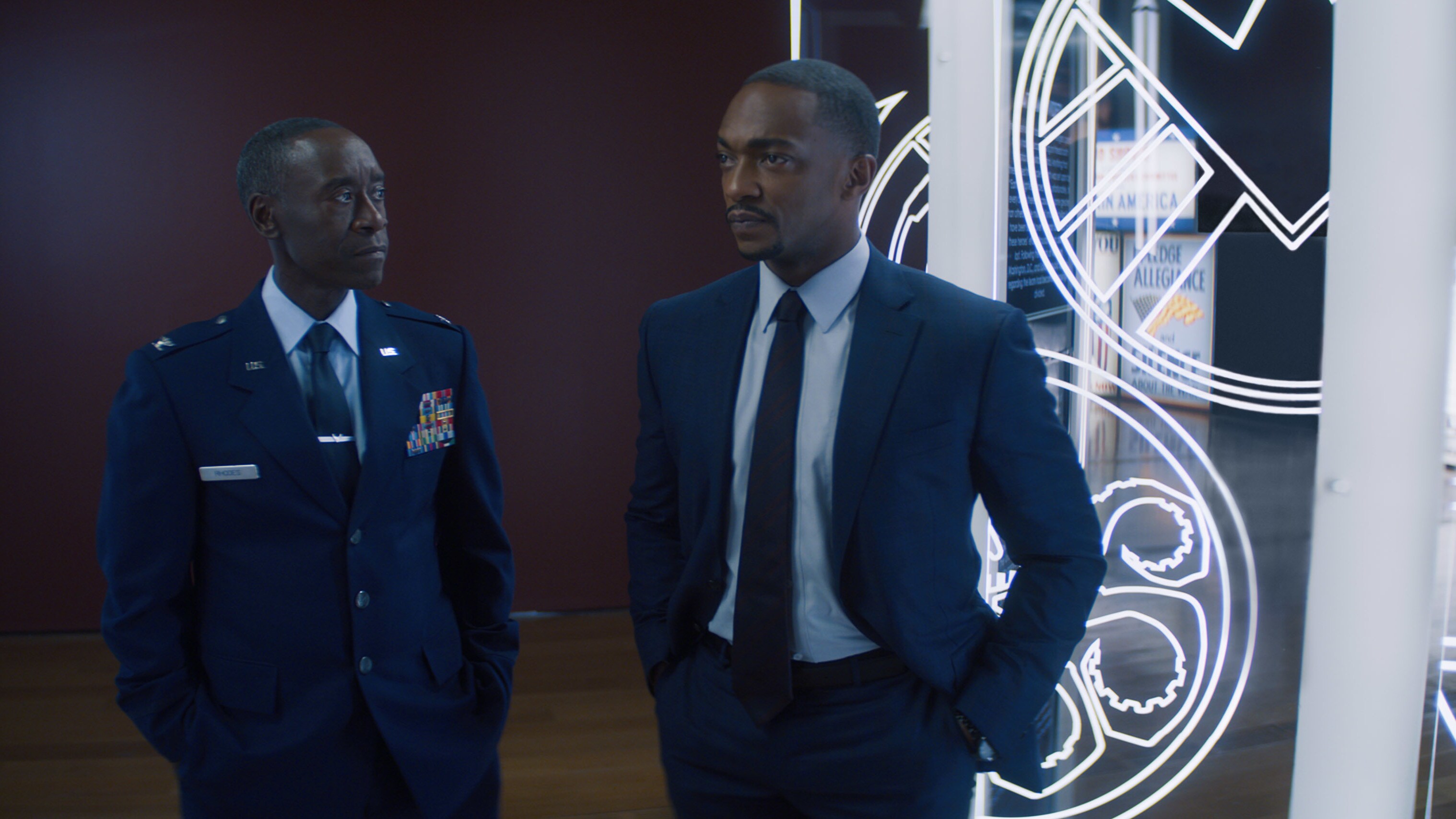 (L-R): Rhodey (Don Cheadle) and Falcon/Sam Wilson (Anthony Mackie) in Marvel Studios' THE FALCON AND THE WINTER SOLDIER exclusively on Disney+. Photo courtesy of Marvel Studios. ©Marvel Studios 2021. All Rights Reserved.