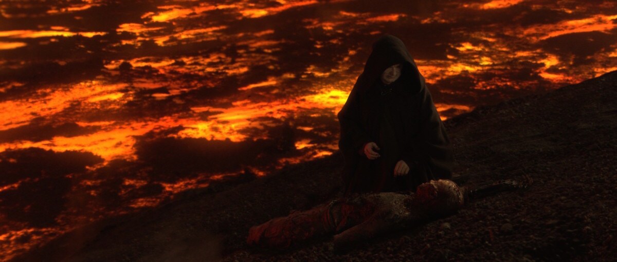 Darth Sidious kneeling over a defeated Anakin Skywalker on Mustafar