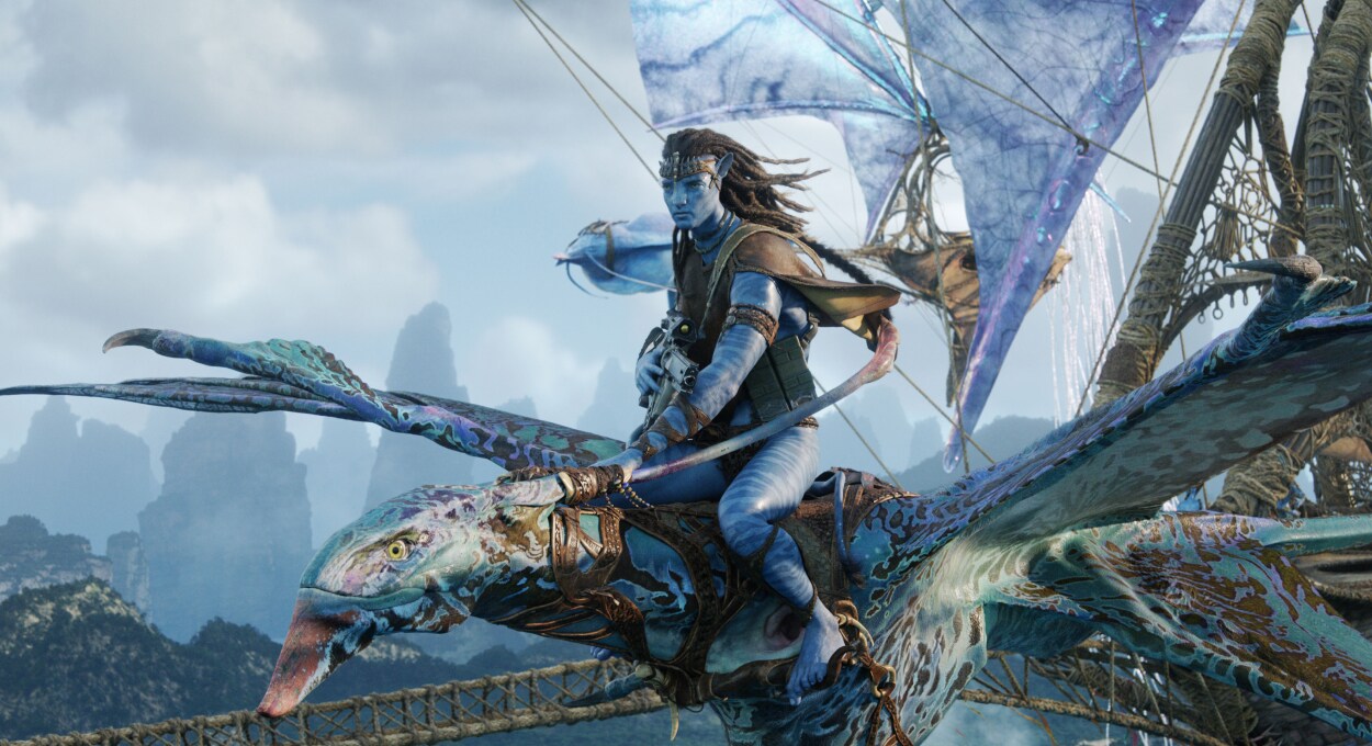 Jake Sully flies through the skies of Pandora on a winged creature in Avatar: Fire and Ash, gripping its reins with focus and determination.