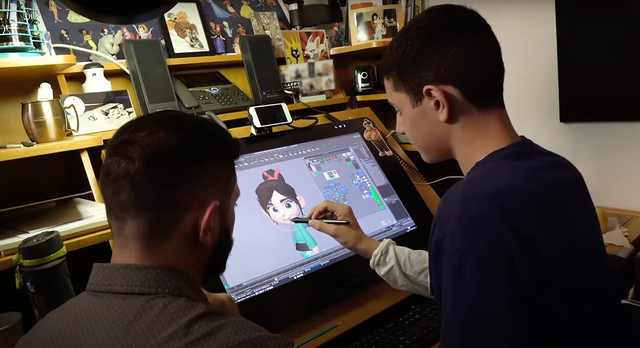 A boy draws Vanellope on a graphic tablet.