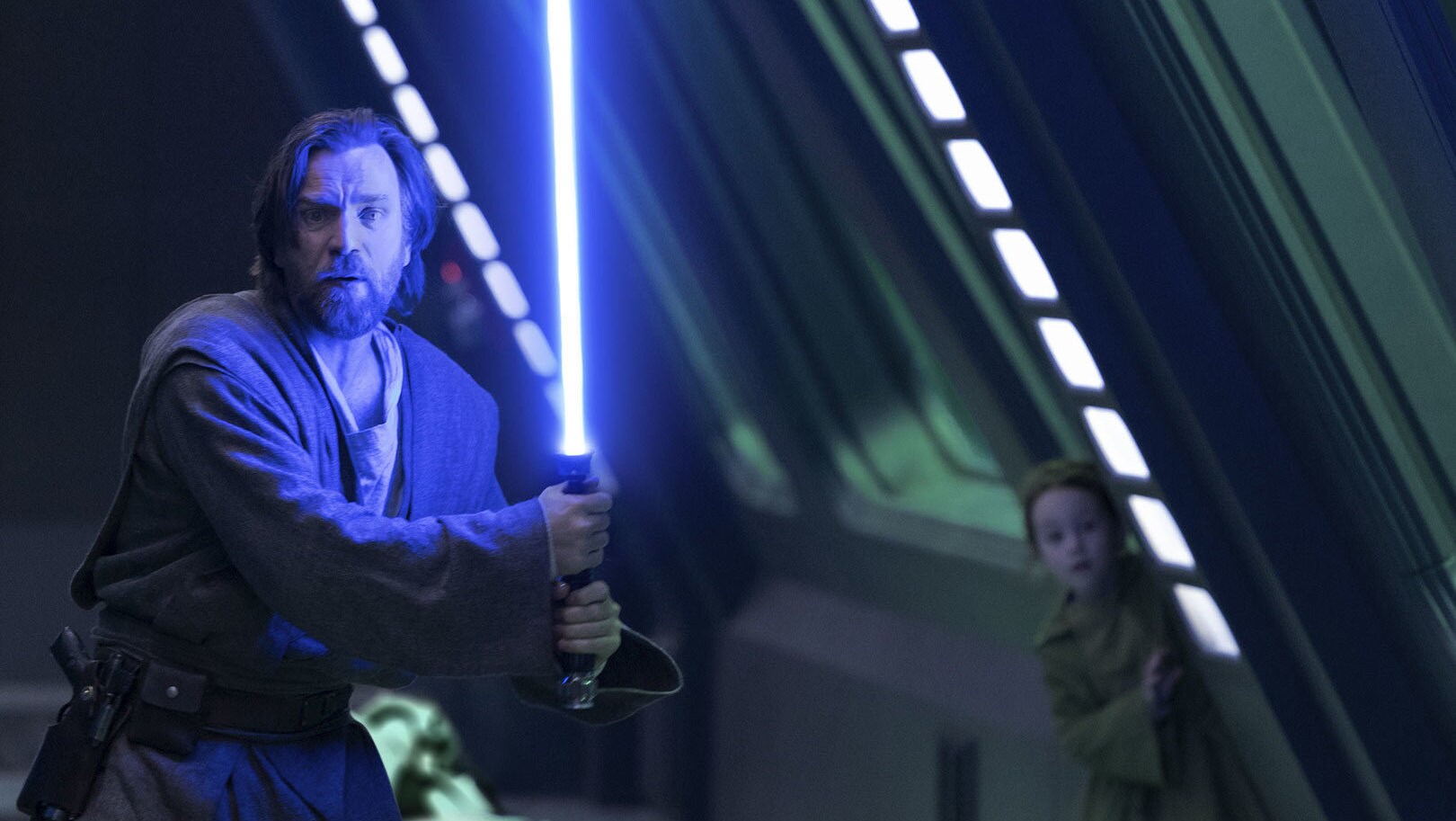 Lightsaber in hand, Obi-Wan protects Leia as they head for an exit.