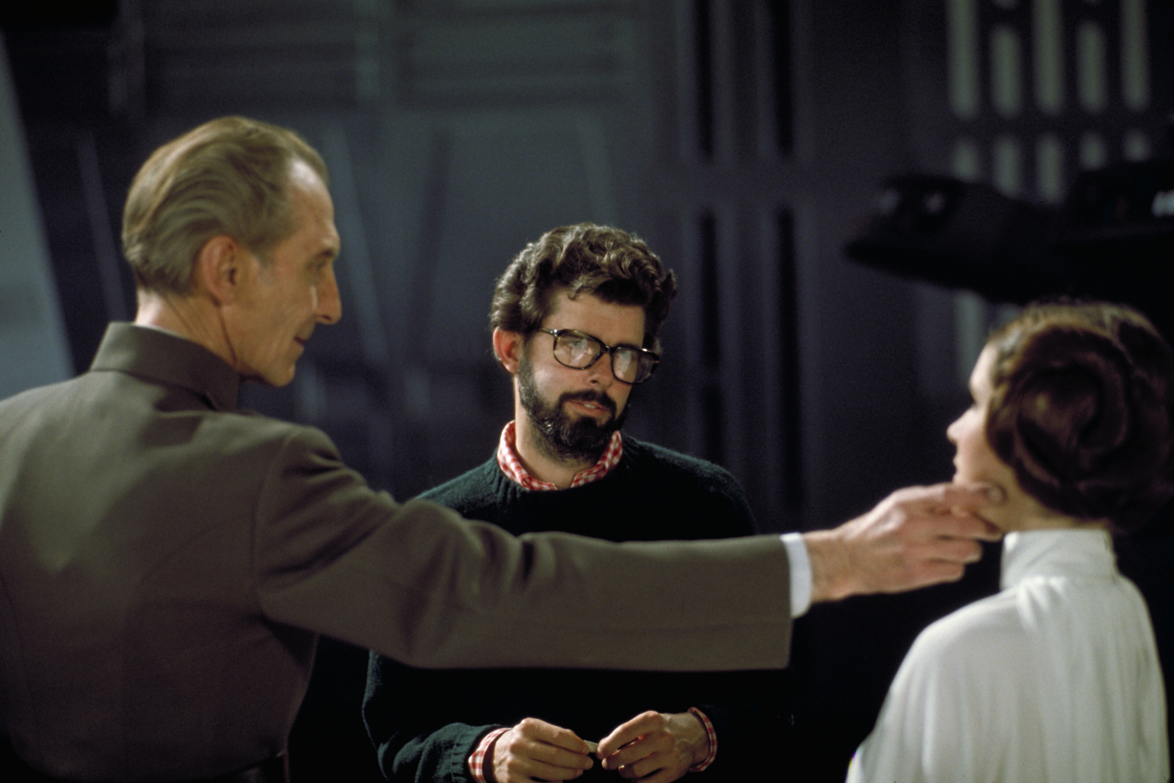Peter Cushing, George Lucas, and Carrie Fisher on the Death Star set, preparing to film Tarkin's ...